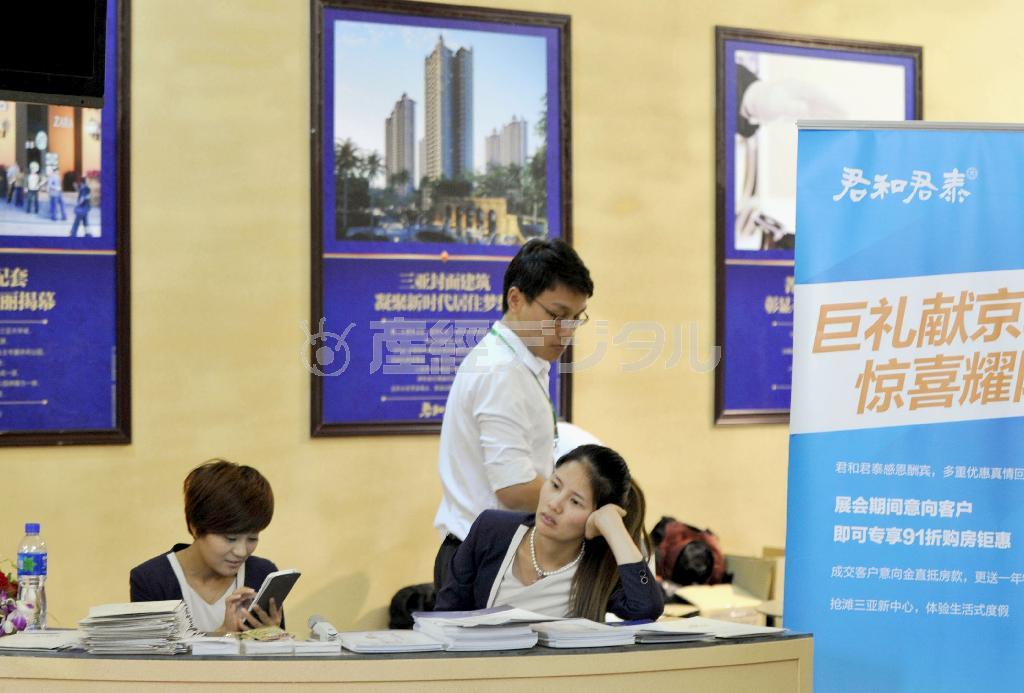 首都北京市内で開催された不動産展示会のブース。訪れる客もまばらなのか、暇を持て余した様子の担当者たち＝２０１４年４月１０日、中国（共同）