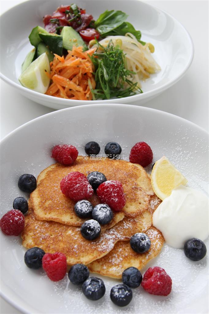 ハワイ・ワイキキビーチ店のオープンを記念して４月いっぱい提供される「バターミルクパンケーキ」。２種類あるうちのフレッシュフルーツとヨーグルト添え（手前）とアヒ・ポキライスボウル＝東京都港区台場の「ｂｉｌｌｓ」お台場（田中幸美撮影）