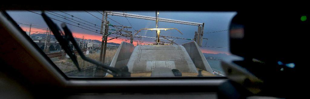 東京駅を出発、西へ向かうドクターイエロー。黄色い車体が都心のビル街に映える＝東京・有楽町