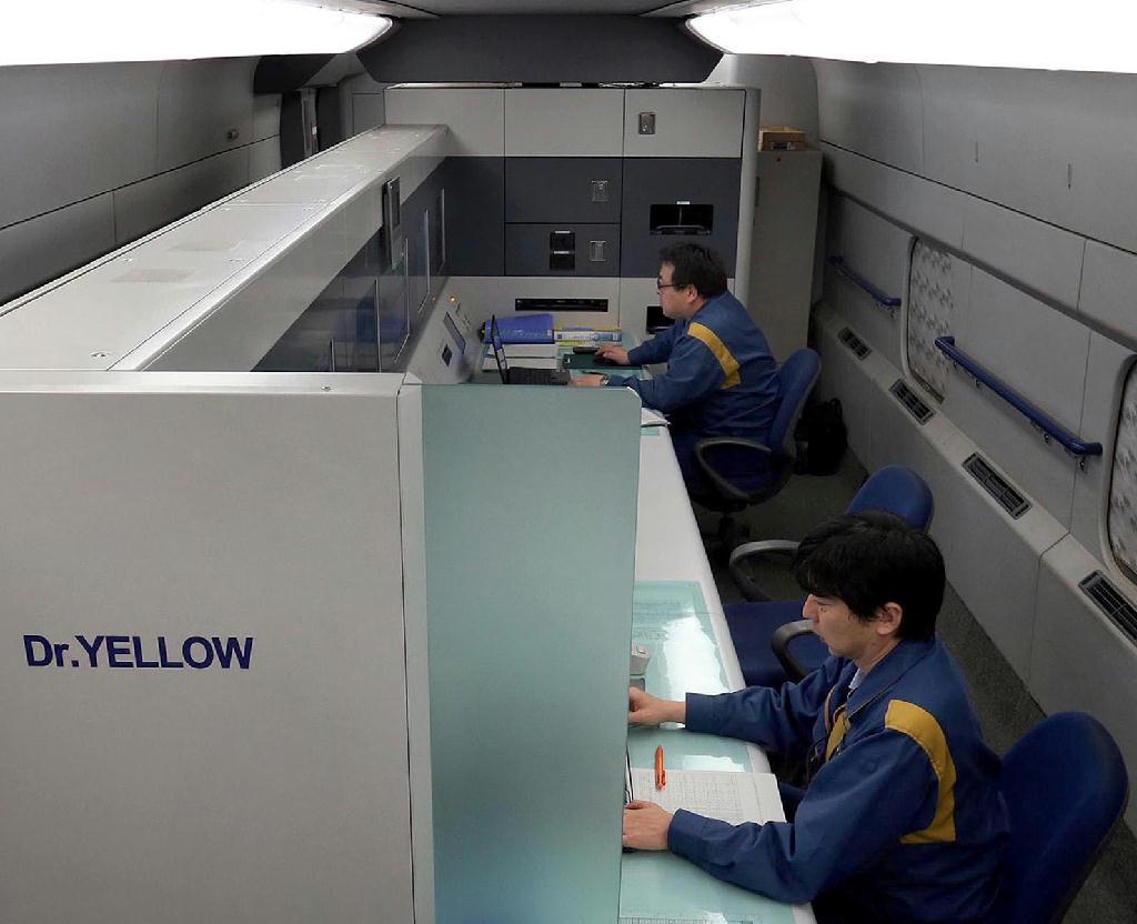 東京駅を出発、西へ向かうドクターイエロー。黄色い車体が都心のビル街に映える＝東京・有楽町