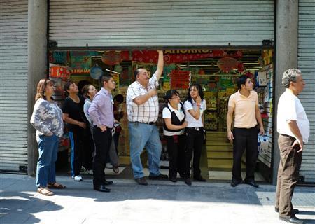 店舗のシャッターを閉め、様子を見守る人々＝メキシコ・首都メキシコ市（緑川真実さん撮影）