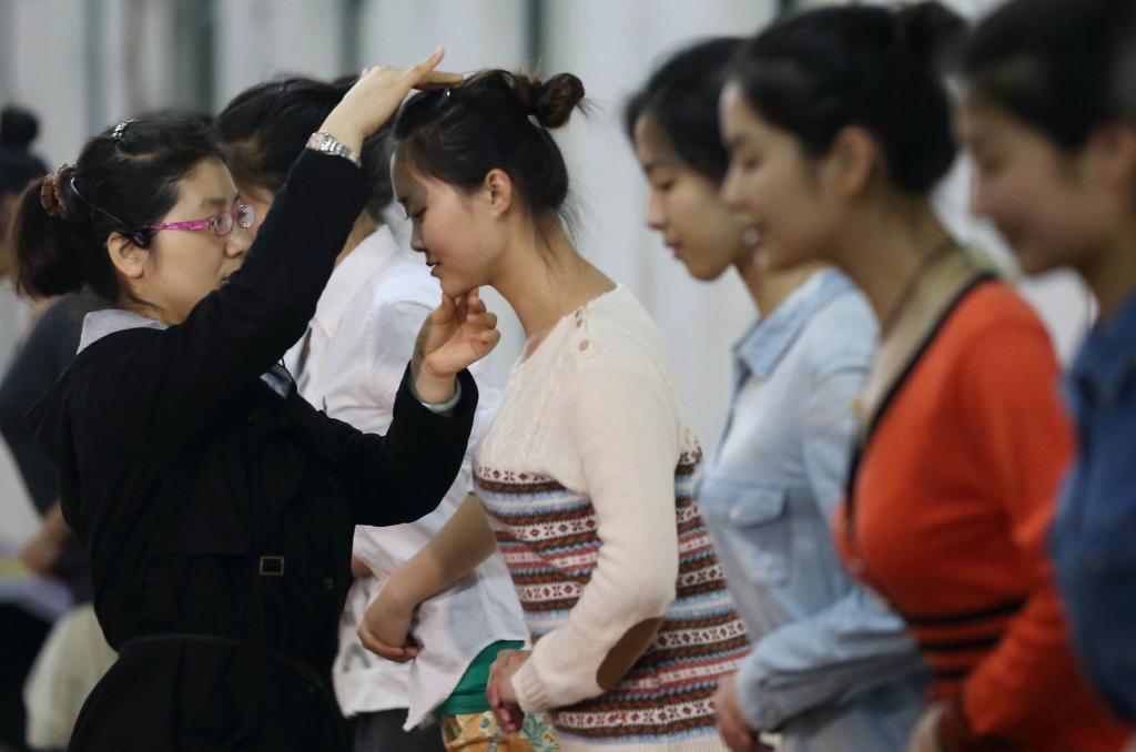 おじぎの練習をする南京の大学生。職業教育と大学の単位の互換制度を呼び掛ける声も上がっている（中国新聞社）