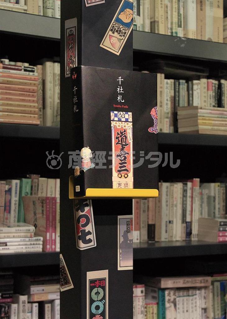 ゴートクジ本楼の書棚に貼られた千社札と、弓岡勝美のコレクションを野島寿三郎らが構成したピエ・ブックスの『千社札』。千社札はうまく貼ると、どんなところも賑やかに、また色っぽくしていくものだ（小森康仁さん撮影、松岡正剛事務所提供）