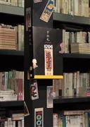 ゴートクジ本楼の書棚に貼られた千社札と、弓岡勝美のコレクションを野島寿三郎らが構成したピエ・ブックスの『千社札』。千社札はうまく貼ると、どんなところも賑やかに、また色っぽくしていくものだ（小森康仁さん撮影、松岡正剛事務所提供）