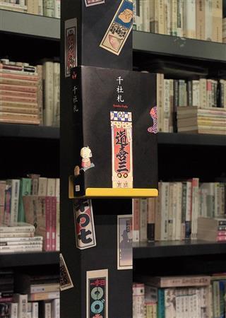 ゴートクジ本楼の書棚に貼られた千社札と、弓岡勝美のコレクションを野島寿三郎らが構成したピエ・ブックスの『千社札』。千社札はうまく貼ると、どんなところも賑やかに、また色っぽくしていくものだ（小森康仁さん撮影、松岡正剛事務所提供）