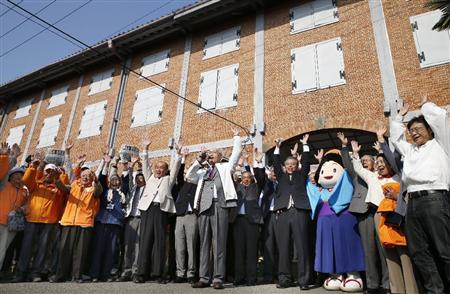 世界文化遺産登録の勧告を受け、富岡製糸場で万歳する地元関係者＝２６日午前、群馬県富岡市