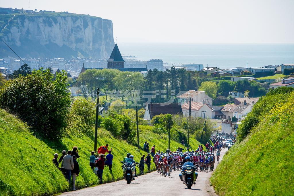終盤に組み込まれた厳しい登坂を含む周回コースを走る。背後にはノルマンディー地方の名所、エトルタの岸壁がそびえる＝２０１４年４月、フランス（田中苑子さん撮影）
