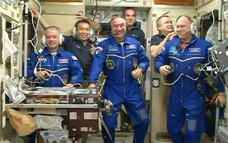 ソユーズ宇宙船でＩＳＳ（国際宇宙ステーション）に到着した米露の３人の飛行士（手前）とともに会見をする船長の若田光一さん（後方左）らクルー＝２０１４年３月２８日（ＮＡＳＡテレビから）