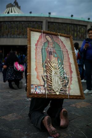 大きなマリア像の絵を背負って巡礼する信者＝２０１２年１２月１３日、メキシコ・首都メキシコ市（緑川真実さん撮影）
