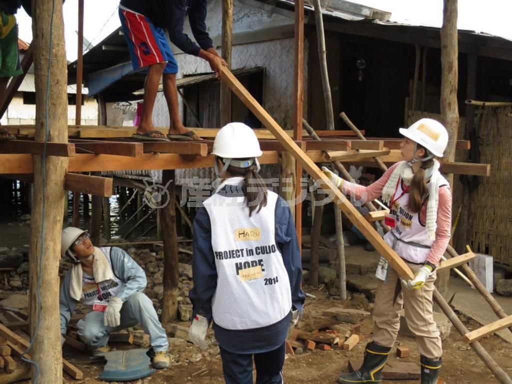 慣れない大工仕事にも一生懸命に取り組む学生ボランティアたち＝２０１４年２月、フィリピン・パワラン州クリオン島（提供写真）