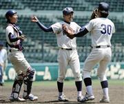 同志社大を破って２３季ぶりの勝ち点を挙げ、冨田真吾（中央）のもとに駆け寄る京大ナイン＝２０１４年５月７日、兵庫県西宮市・甲子園球場（共同）