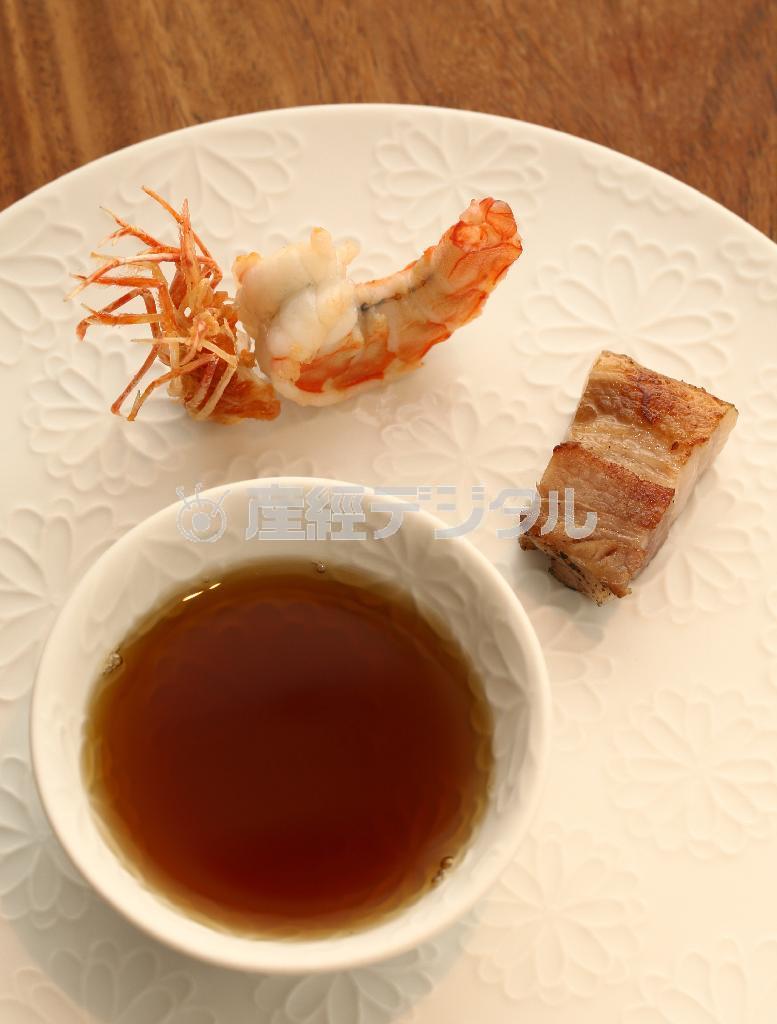 熱々のコンソメスープに、エビのソテーと自家製ベーコンを添えて。白い器も美しい一品