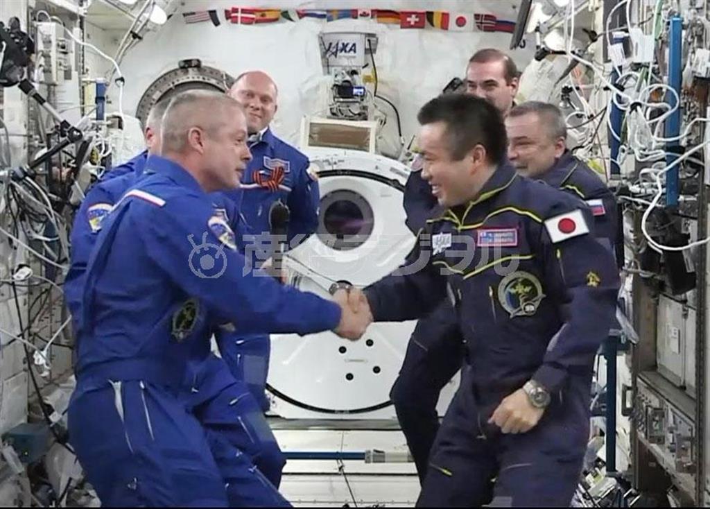 後任のスティーブン・スワンソン飛行士（左）と握手し、国際宇宙ステーション（ＩＳＳ）の船長任務を引き継ぐ若田光一さん（右）＝２０１４年５月１３日未明（日本時間、ＮＡＳＡテレビから）