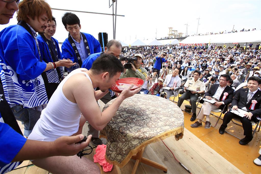 この写真で、絞りを決める時に大切なのは、飲み干す人を見る８０００人の観客です＝２０１４年４月２７日、高知県香南市（須藤夕子さん撮影）