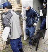 家宅捜索を行ったＡＳＫＡ容疑者の自宅を出る捜査員と麻薬探知犬＝２０１４年５月１７日午後２時２４分、東京都目黒区（共同）