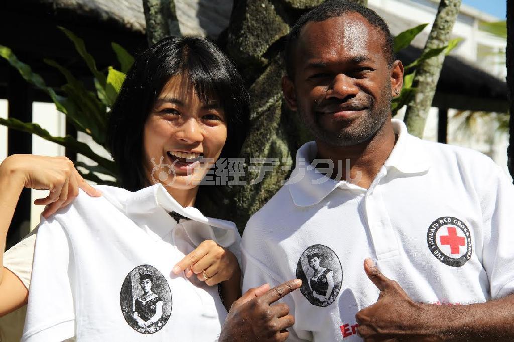 昭憲皇太后のお顔がプリントされたＴシャツを紹介する相川梨絵さん（左）＝バヌアツ（相川梨絵さん提供）