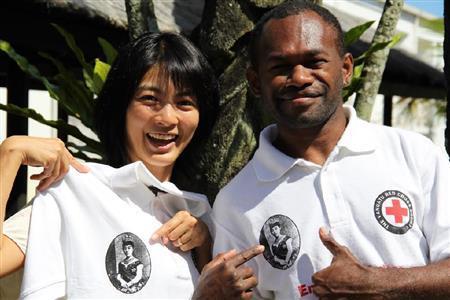 昭憲皇太后のお顔がプリントされたＴシャツを紹介する相川梨絵さん（左）＝バヌアツ（相川梨絵さん提供）