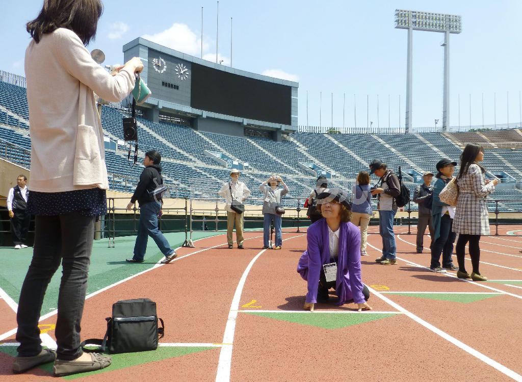 国立競技場のスタートラインで記念撮影する参加者＝２０１４年５月７日、東京都新宿区（共同）