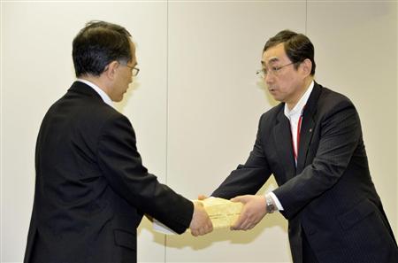 東海第２原発の審査に関する申請書を原子力規制委員会に提出する日本原電の増田博副社長（右）＝２０日午後、東京都港区