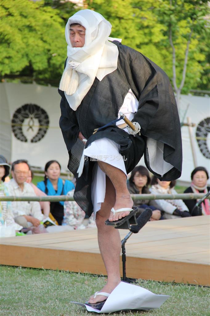 僧兵の衣装を身につけた興福寺衆徒によって行われる「舞台あらため」。敷いた紙を踏みつけて芝生の湿り具合を調べる古式ゆかしき儀式だ＝２０１４年５月１７日、奈良県奈良市登大路町の興福寺南大門跡（田中幸美撮影）