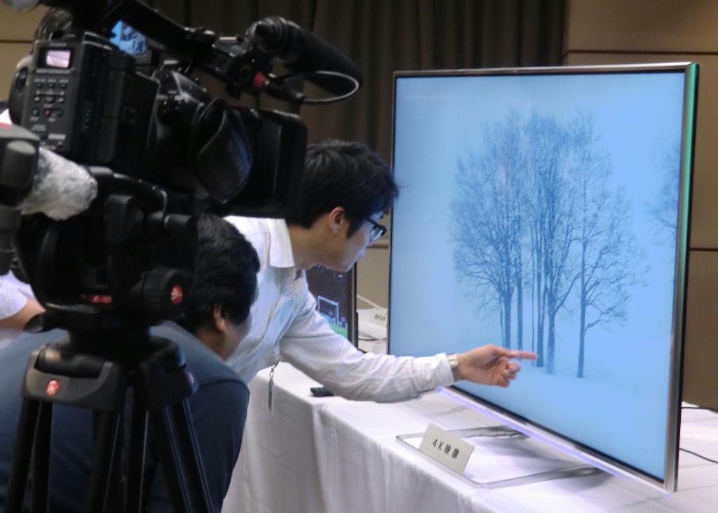 ＮＴＴなどによる発表会の会場で、光回線で伝送された４Ｋ映像の解像度の高さを確認する報道陣＝２１日、東京都千代田区