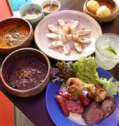 ブラジル料理店「サウダーデ」の人気料理。（右手前から時計回りに）シュラスコの盛り合わせ、フェイジョアーダ、ムケッカ、パルミット。右奥は、モチモチした食感で日本でもおなじみのチーズパン、ポン・デ・ケージョ