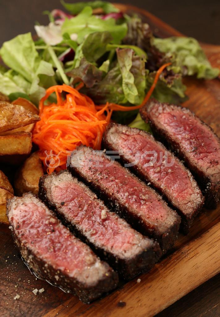 十勝ハーブ牛を使った「ステーキフリット」（サーロイン１００グラム１８００円、ランプ１００グラム１５００円。注文は２５０グラムより）は、たっぷりのサラダとフライドポテトが添えられている。味付けは塩、コショウのみとシンプルで噛めば噛むほど肉本来の味わいが楽しめる