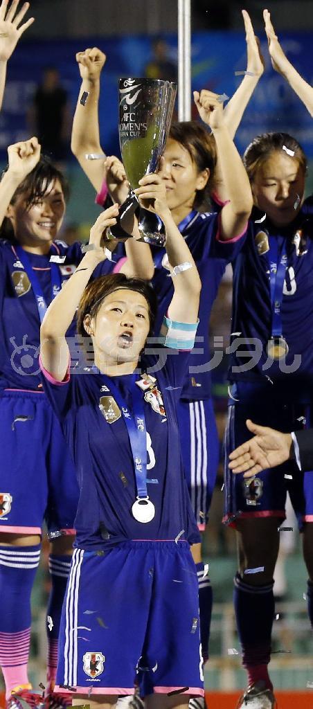 アジアカップを授与され高々と掲げる主将の宮間あや。後ろは左から川澄奈穂美、岩清水梓（あずさ）、澤穂稀（ほまれ）＝２０１４年５月２５日、ベトナム・ホーチミン（共同）