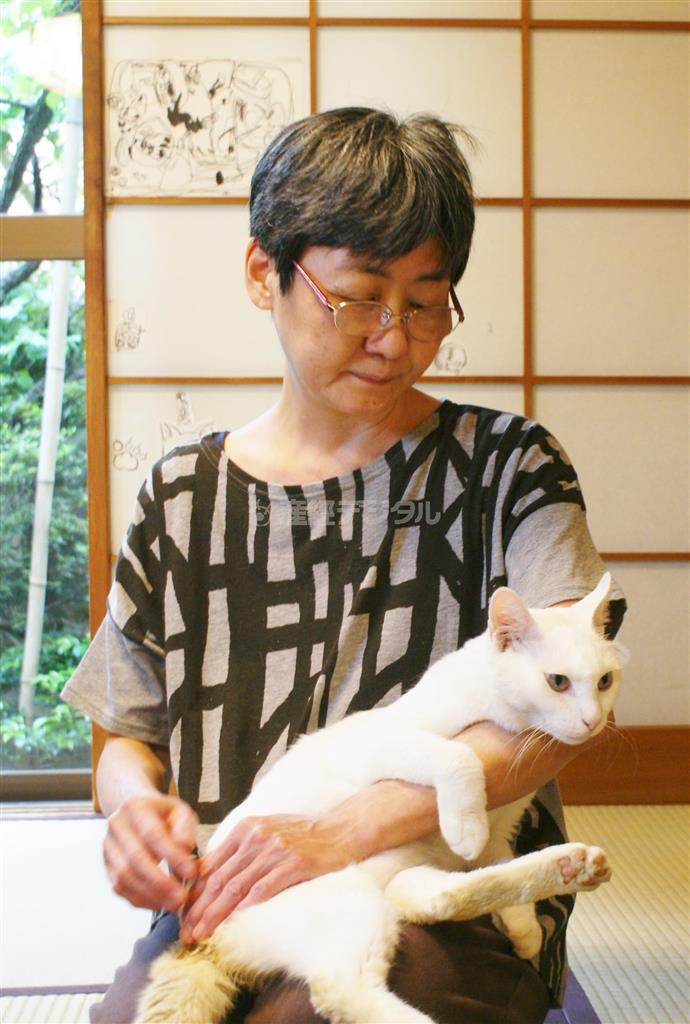 漫画家、エッセイストのハルノ宵子（よいこ）さんと“運命の猫”シロミ。カメラを構えると必ずポーズをとってくれるという女優っぷり＝２０１４年５月２０日、東京都文京区（塩塚夢撮影）