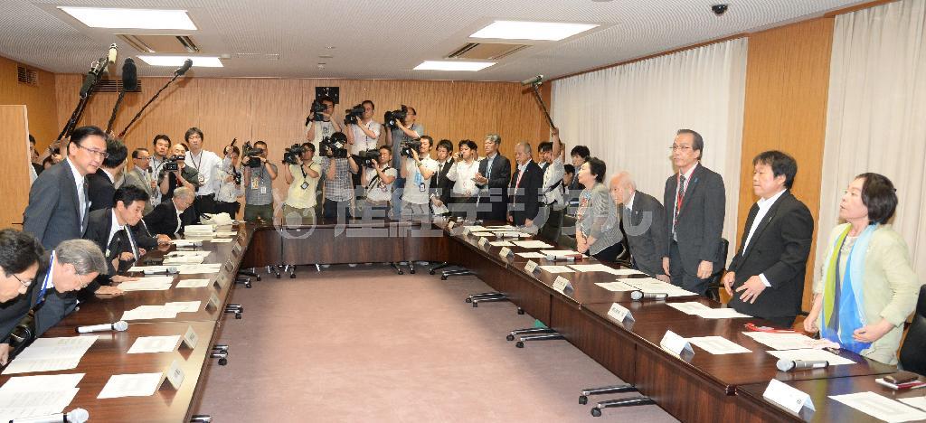 日朝政府間協議を受けた説明会に臨む拉致被害者家族ら（右側）と、政府側を代表して挨拶に立つ古屋圭司（けいじ）拉致問題担当相（左端）＝２０１４年５月３０日、内閣府（財満朝則撮影）