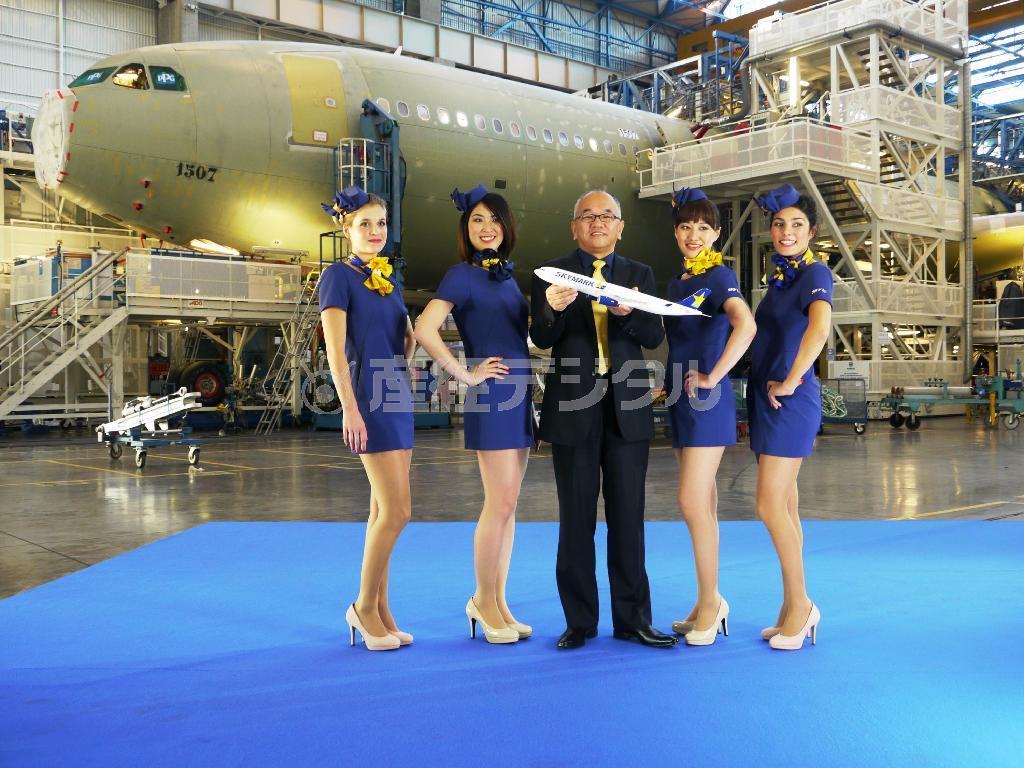 フランス南西部、トゥールーズのエアバス本社で昨年12月、４月から投入するエアバスＡ３３０のモデルを手にする西久保慎一社長（中央）と、〝ミニスカCA〟たち
