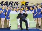 エアバスＡ３３０のシートに座るスカイマークの西久保慎一社長とミニスカートの客室乗務員＝３月７日、羽田空港