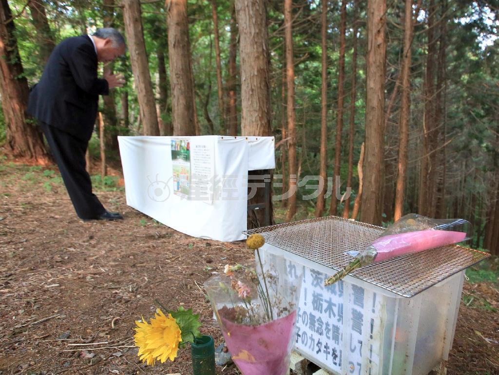 吉田有希（ゆき）ちゃんの遺体が遺棄された現場に設置された献花台に手を合わせる近隣住民＝２０１４年６月３日午後、茨城県常陸大宮市三美（桐原正道撮影）