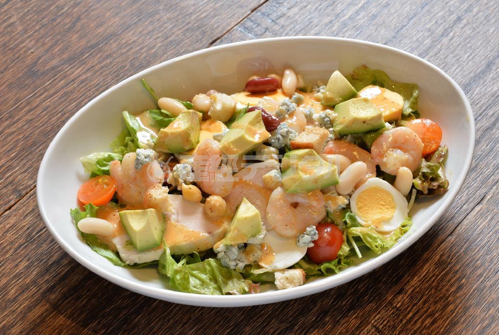 アボカドやエビ、豆類、ブルーチーズに加え、ドレッシングの最後にケイジャンソースをかけるという「コブサラダ」（１３００円）＝２０１４年４月２１日、大阪市中央区（沢野貴信撮影）