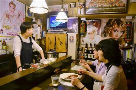 宝塚ファンの常連客と語らう元タカラジェンヌの関弘子さん（左）＝２０１４年６月６日、東京都中央区銀座（共同）