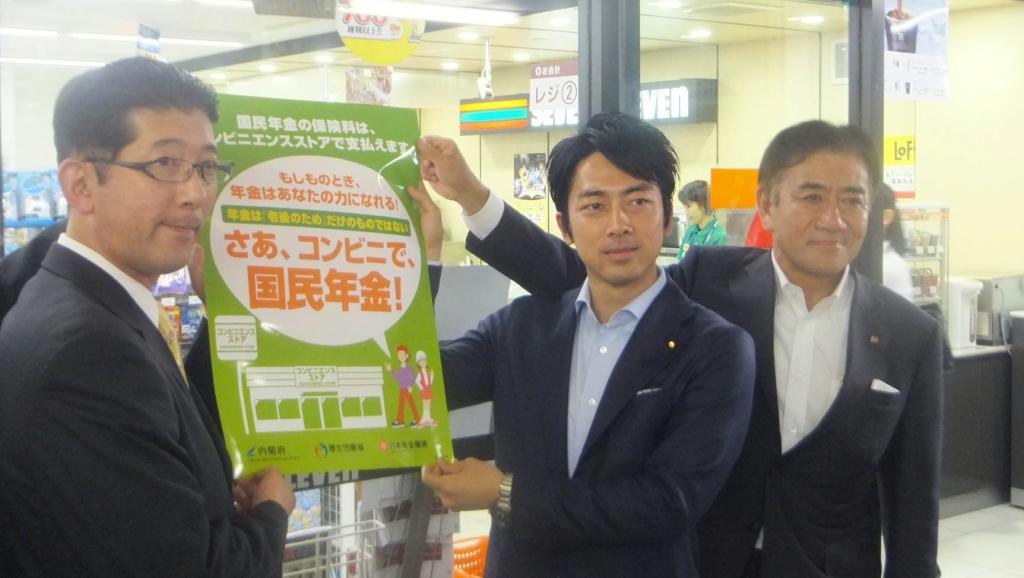 ポスターを掲げる井阪隆一セブン－イレブン・ジャパン社長（右）ら＝９日、東京都豊島区