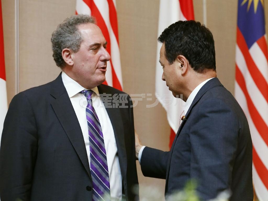 ＴＰＰ（環太平洋戦略的経済連携協定）をめぐる閣僚会合での共同記者会見を終え、言葉を交わすマイケル・フロマン米通商代表（左）と甘利明（あまり・あきら）ＴＰＰ担当相＝２０１４年５月２０日、シンガポール（共同）