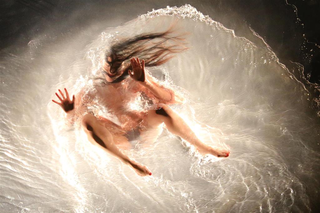 初日公演前日のリハーサルで、観客の頭上に出現する透明プールの演目「ＭＹＬＡＲ（マイラー）」で演者が下を覗くとまるで天をはうように見える＝２０１４年５月９日、東京都港区（中尾由里子さん撮影）