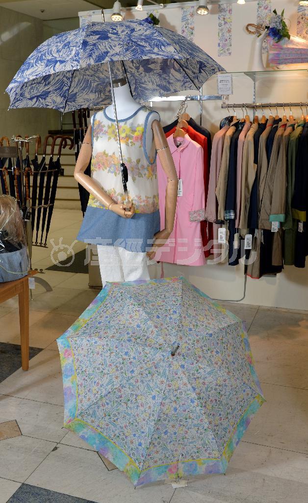 エレガントな植物柄は今年のトレンド。手持ちの白×ブルーの傘は１万円、パステルカラーの傘は１万１０００円＝２０１４年６月４日、東京都中央区（栗橋隆悦撮影）