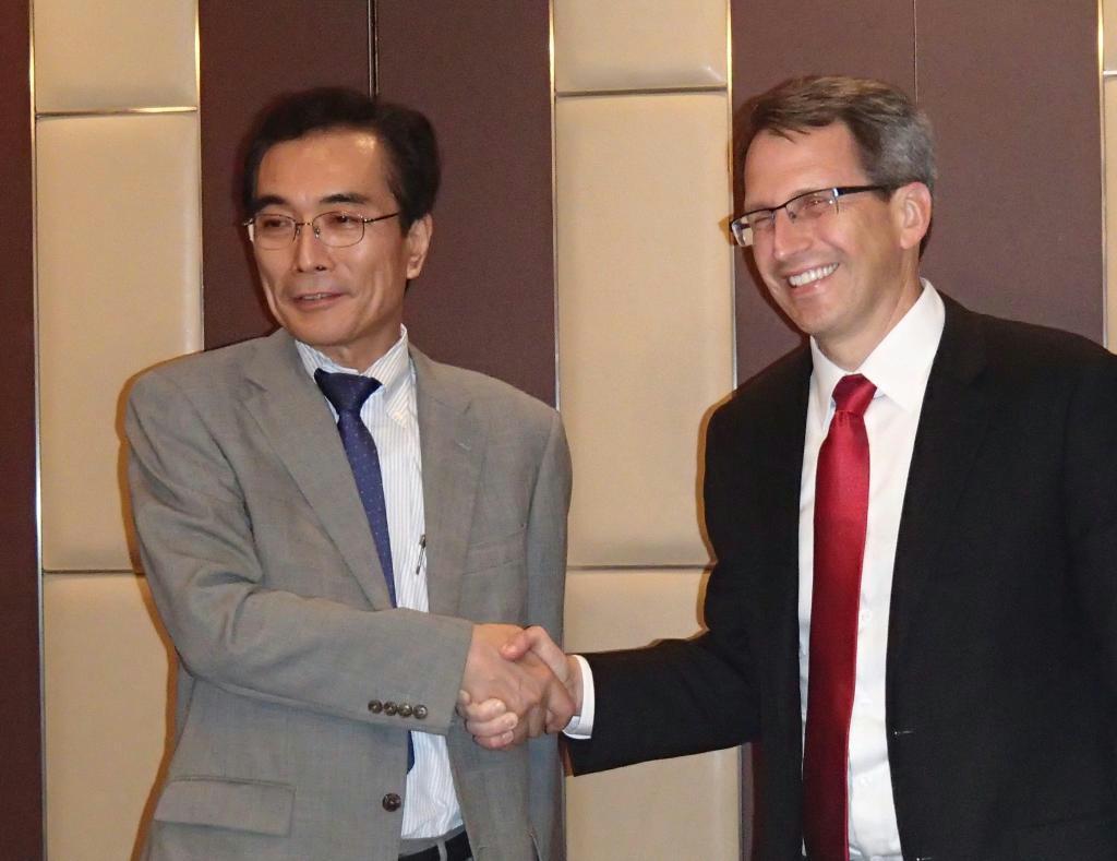 握手を交わすシナプティクスのリック・バーグマン社長（右）とルネサスエスピードライバの工藤郁夫社長＝１１日、東京都千代田区