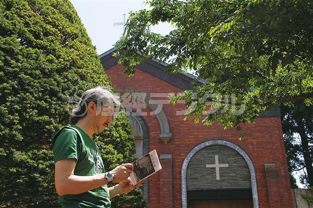 函館のトラピスト修道院の庭で、自著『僕の音、僕の庭』を手にする井上鑑。この静かな風情の奥に、実に自在な音楽力とすこぶるラディカルな思考が秘められている＝北海道・函館市（小森康仁さん撮影、松岡正剛事務所提供）