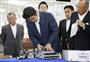 双腕型産業用ロボットを導入した、グローリー株式会社埼玉工場で製品（レジの釣り銭機）のユニットを手に取る安倍首相＝１９日午前９時２５分、埼玉県加須市（代表撮影）