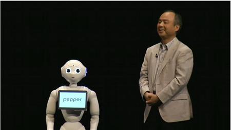 ソフトバンクの株主総会の模様。壇上で孫正義社長は新発売するロボット「ｐｅｐｐｅｒ」とかけあう＝6月20日、同社の動画配信より