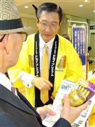 中元コーナーの客に高級ビールを売り込むアサヒビールの小路明善社長＝２０日午前、東京都中央区の高島屋日本橋店