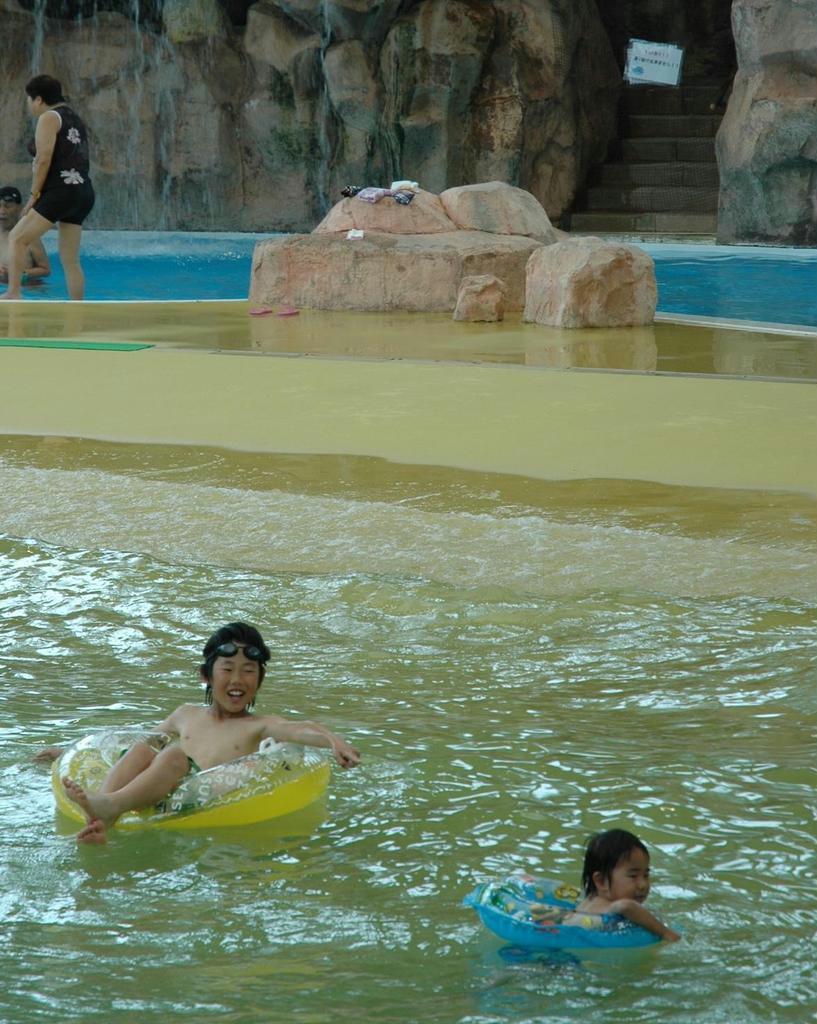 夏になるのが待ち切れず、浮輪で遊ぶ子供たち＝大阪市鶴見区の鶴見緑地プール