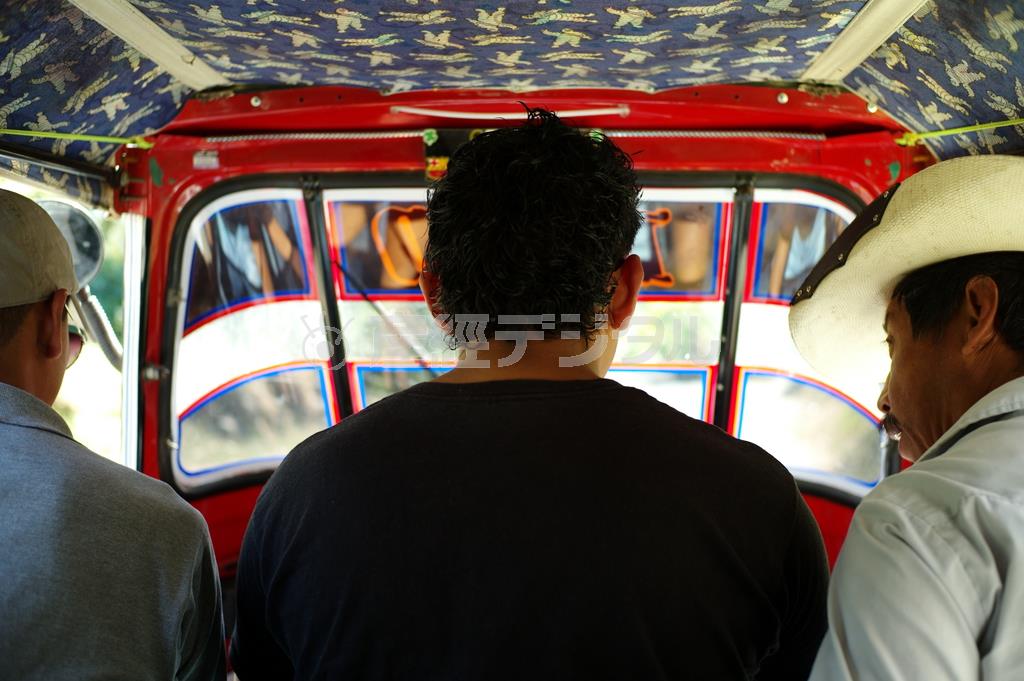 サンペドロ・ラ・ラグーナの埠頭には、「公式観光ガイド」を名乗る男性らが待機していて、コーヒー農園や山登りなど観光ツアーに誘って来る。２人のガイドに誘われ、登山道入り口までトゥクトゥクに乗車した＝２０１２年１２月２９日、グアテマラ（緑川真実さん撮影）