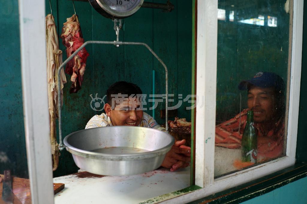 カメラに笑顔で応える肉屋の青年＝グアテマラ南部のサンペドロ・ラ・ラグーナ（緑川真実さん撮影）