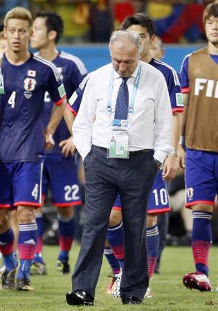 １次リーグ敗退が決まり、うつむきながら引き揚げるザッケローニ監督。左は本田＝クイアバ（共同）