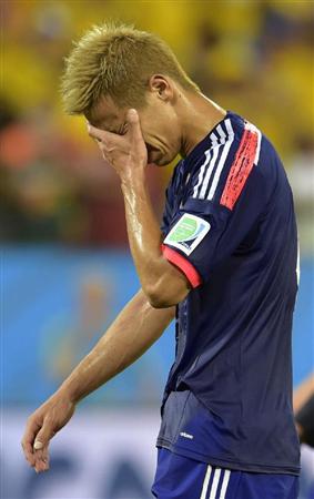 １次リーグ敗退が決まり、顔を覆う本田＝クイアバ（共同）