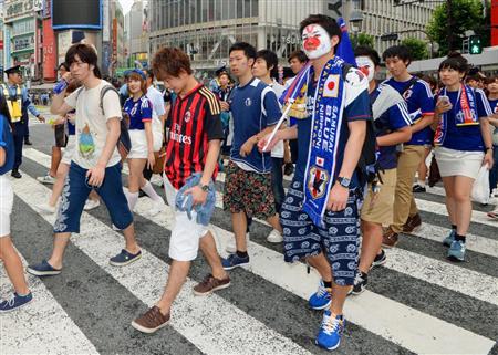 日本の１次リーグ敗退が決まり、肩を落とし引き揚げるサポーター＝２５日朝、東京・渋谷のスクランブル交差点